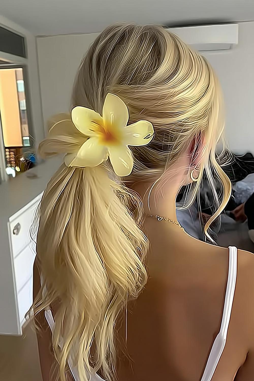 Tropische Plumeria im Haar